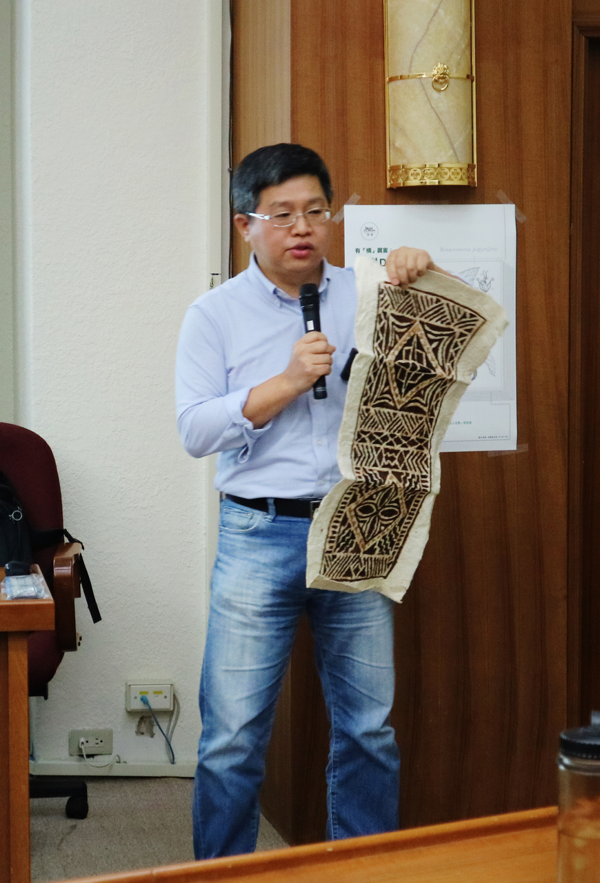 Chung displaying a piece of bark cloth.