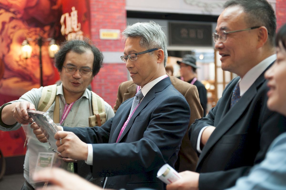 President Liao viewing historic buildings with an AR device in the section of <em>Recreating Old Taipei</em>.